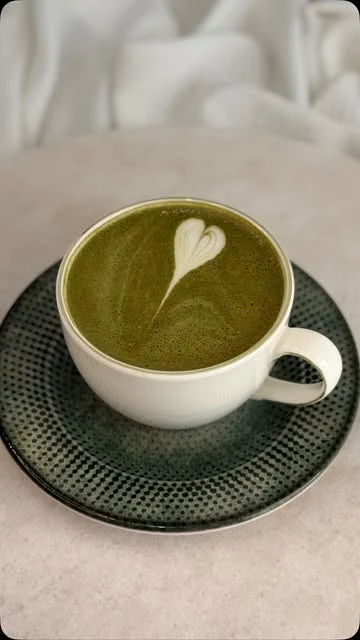 Bebida verde con corazón de espuma